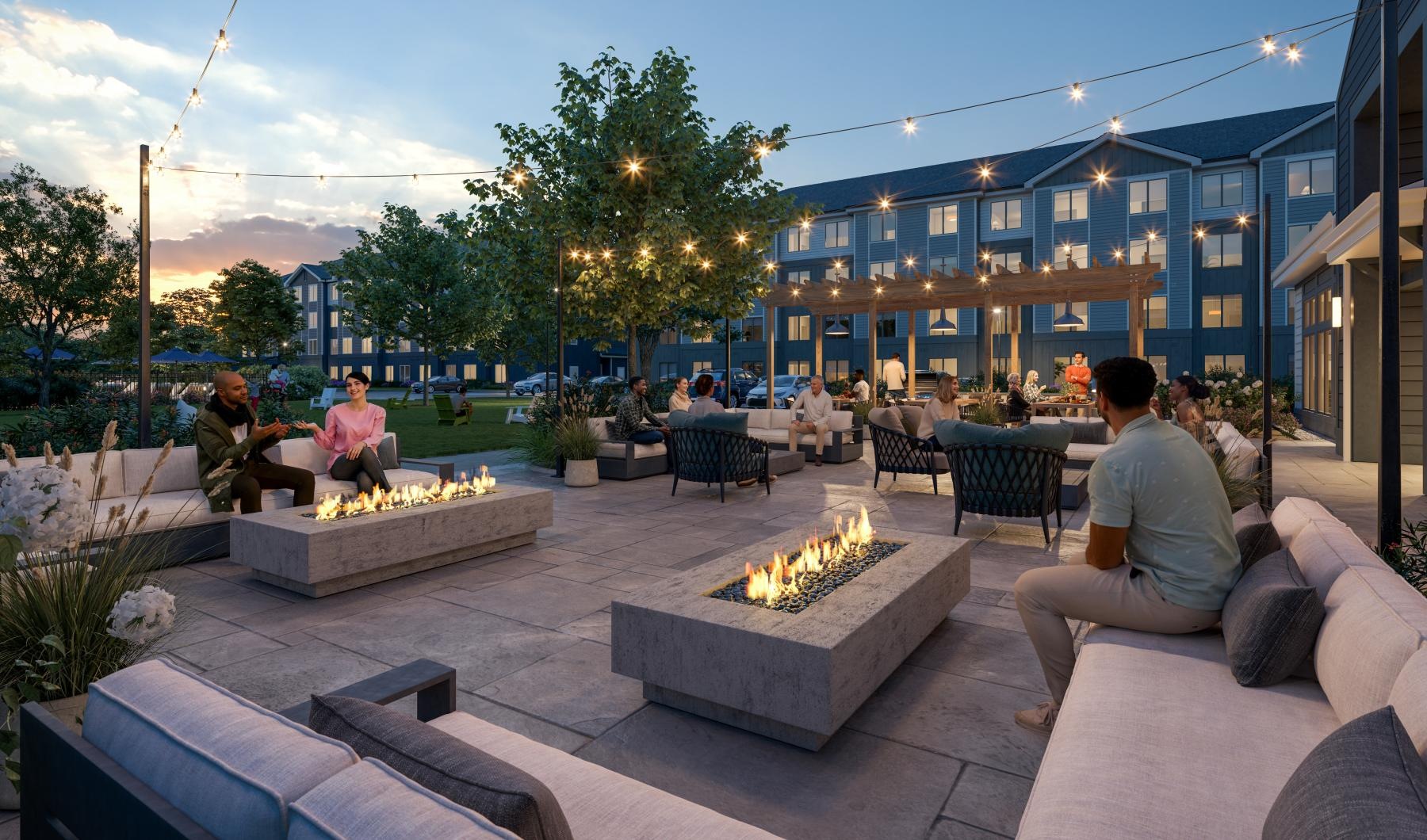 a group of people sitting around a fire pit in front of a building