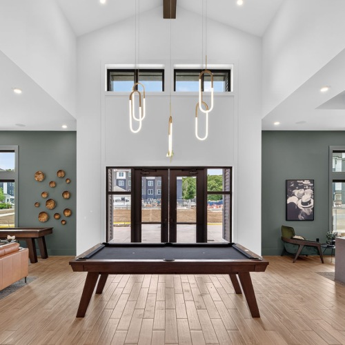 a clubroom with a pool table, couch and tables