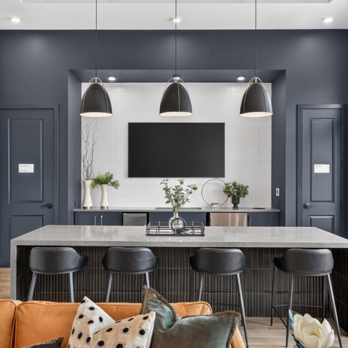a clubroom kitchen with a tv, table and chairs